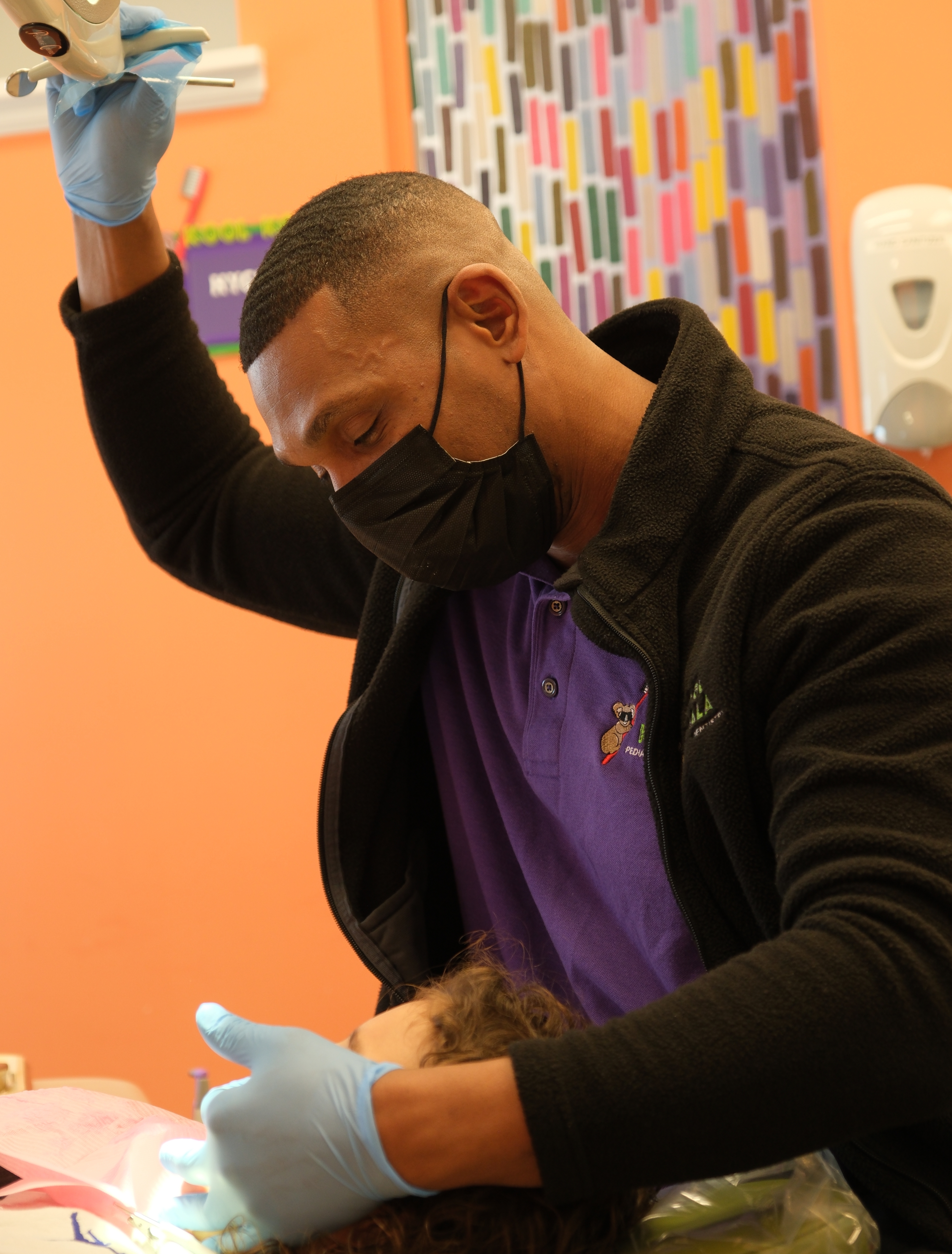 Man working on a patient's teeth in a dental chair