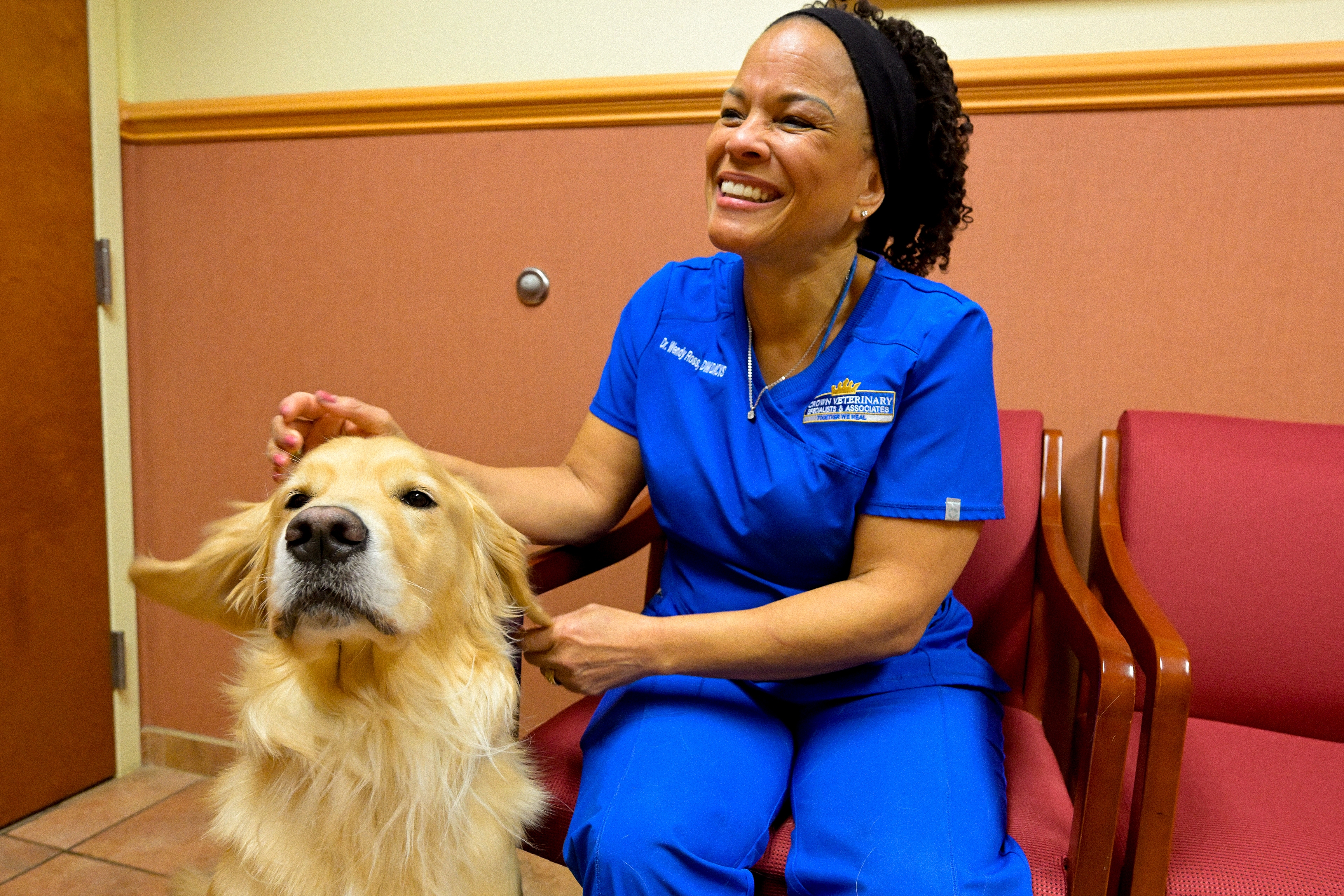 Dr. Ross smiling with a dog