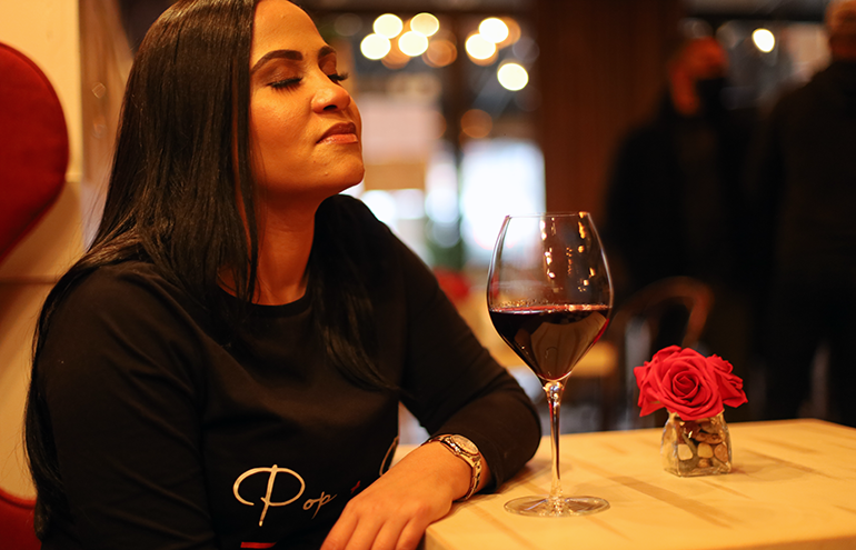Yajaira Gonzalez with a glass of wine in her restaurant