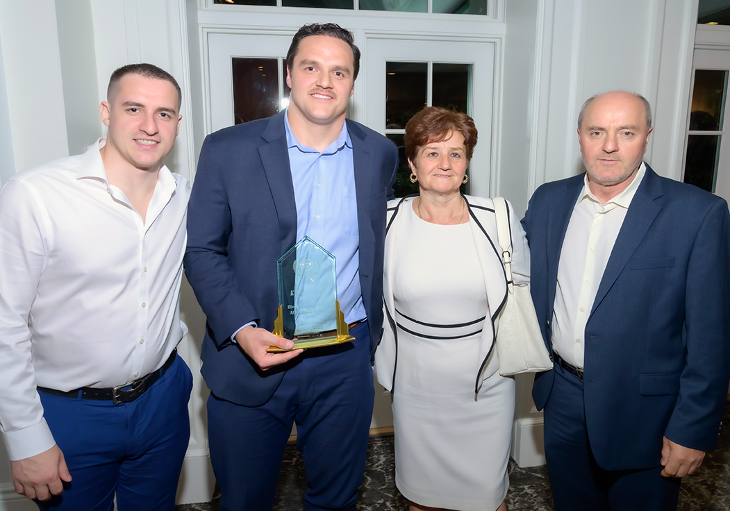 From left to right: Kristjan's brother, Kristjan holding an award, Kristjan's mother, Kristjan's Father