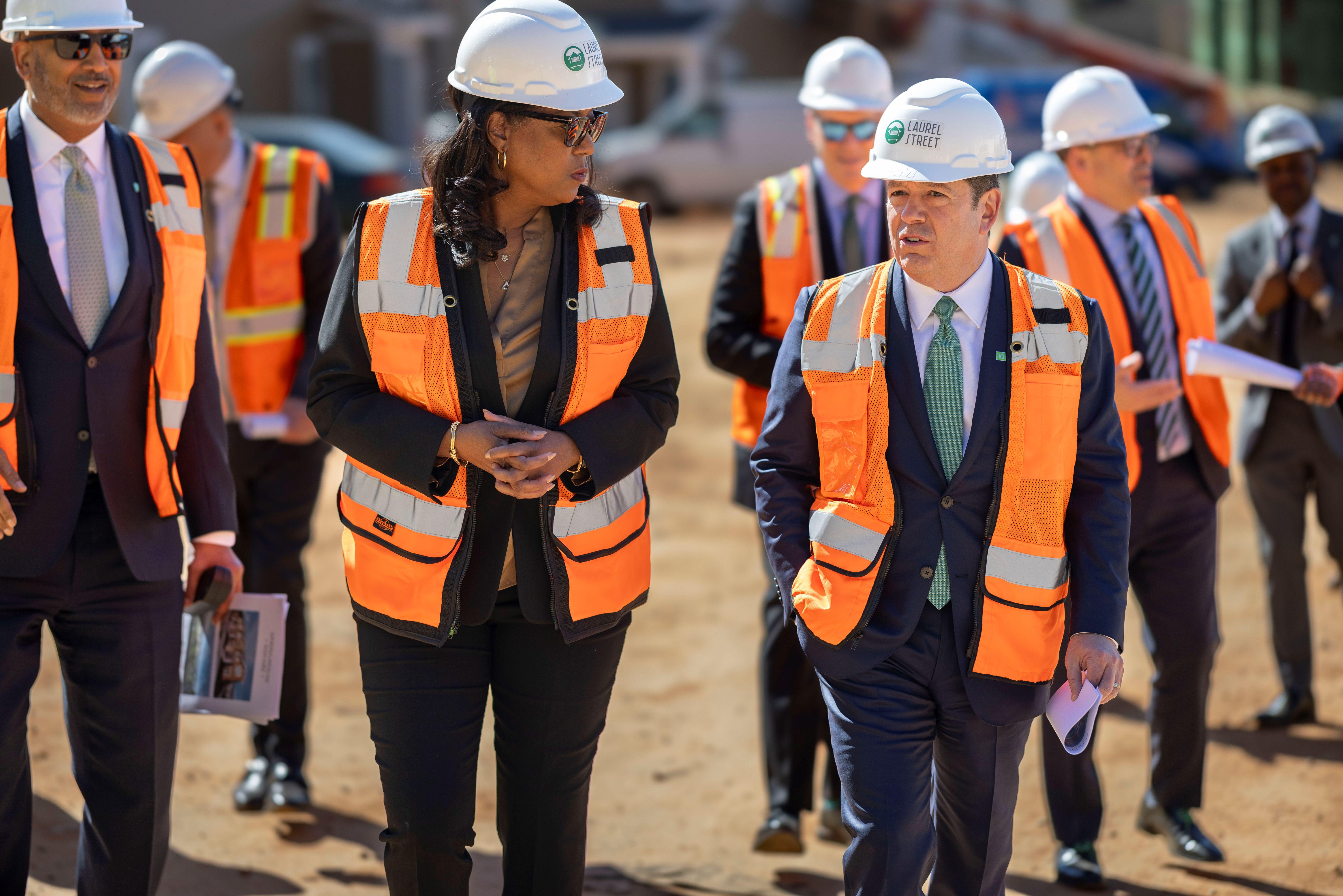 Dionne Nelson (left) and Leo Salom (right) in hard hats on a construction site