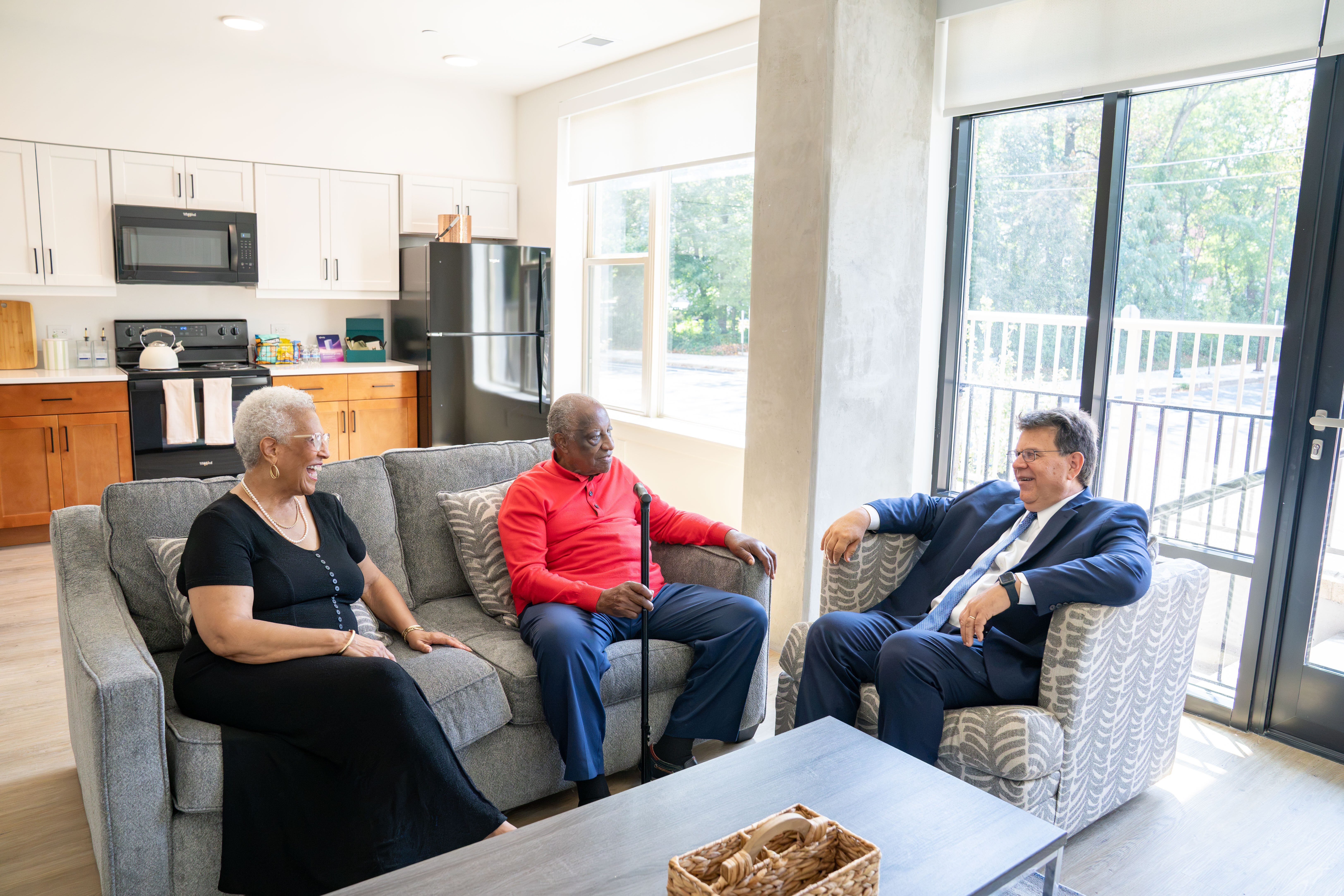 A woman, a man, and a man sitting in an apartment
