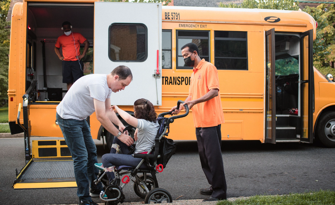young girl in wheelchair getting put on a school bus