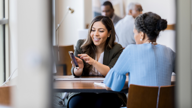 Woman showing her phone to a banking customer service representative
