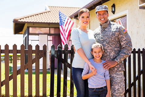 Veteran family standing in front of home