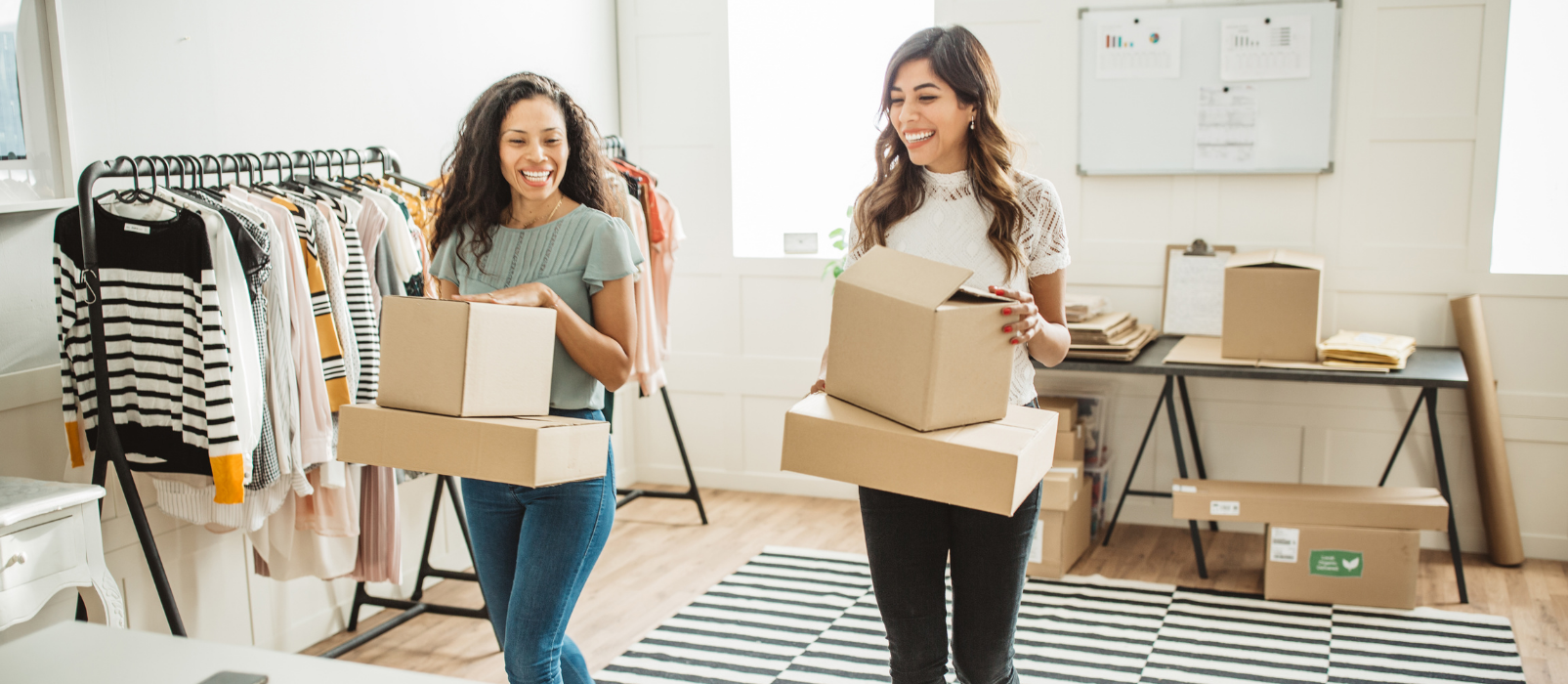 Two women in a shop holding boxes