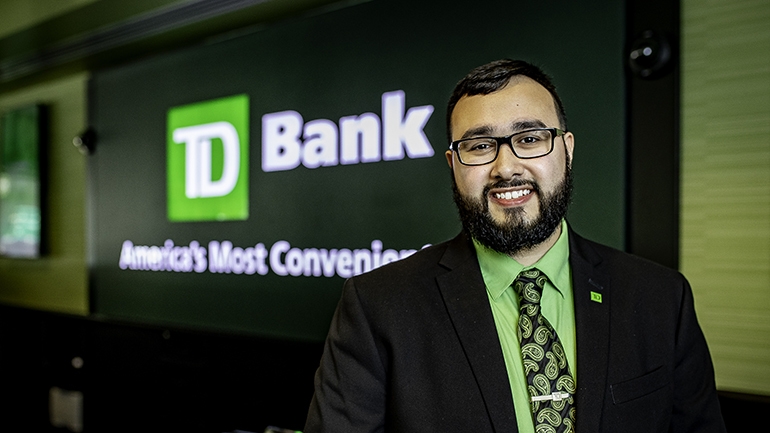 Man standing in store in front of TD sign