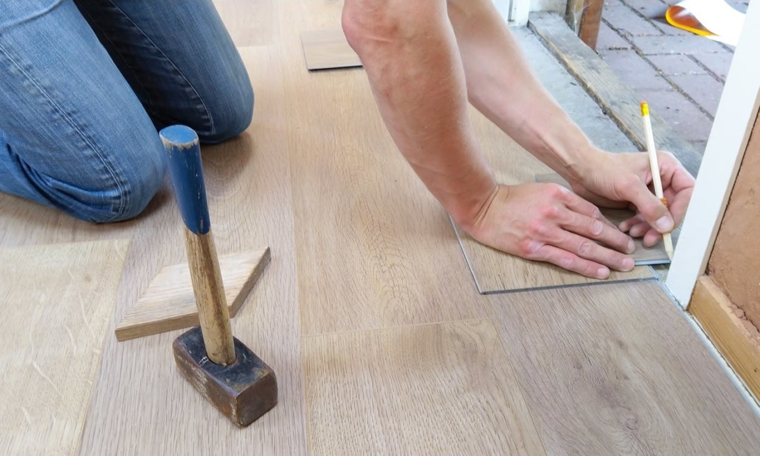 man doing work on floor with hammer