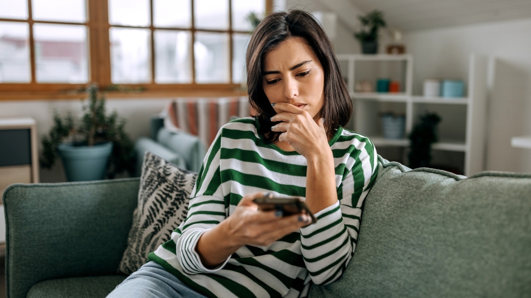 Image of a women on a couch looking at her phone