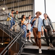 Smiling college students walking down stairs to their next class stock photo