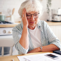 Older woman looking distressed at forms