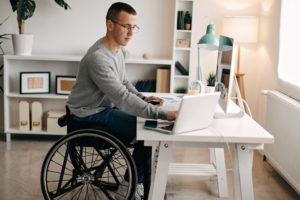 Young man in wheelchair works from home.
