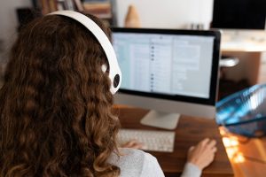 Woman on computer with headphones