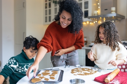 Image of a woman with two children baking cookies.