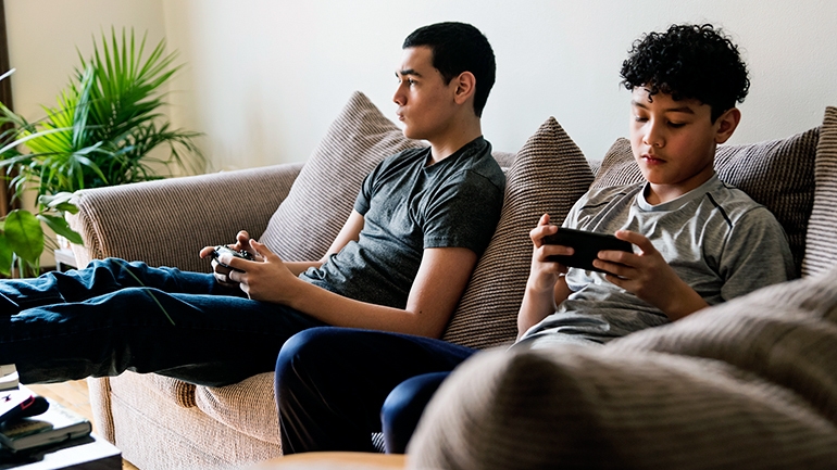 Teens playing video games inside