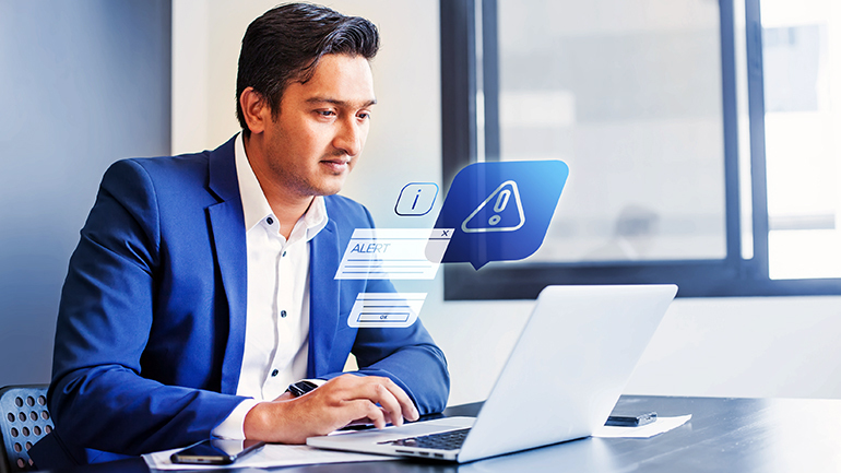 man on laptop with alert graphics around it
