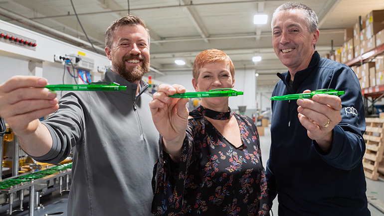 Employees holding TD Bank pens in the warehouse