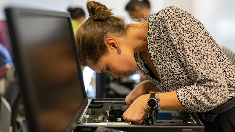 young woman taking apart computer tech