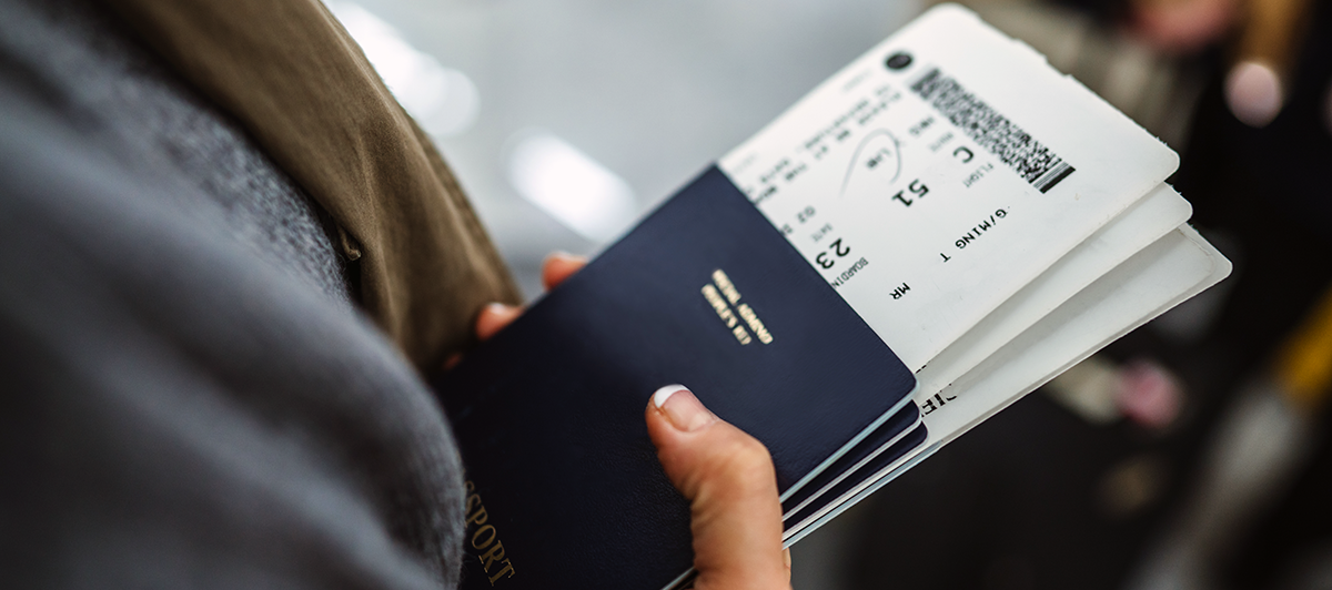 Woman holding a passport with plane tickets