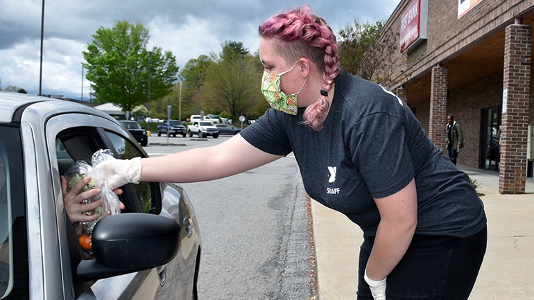 YMCA volunteer handing out supplies