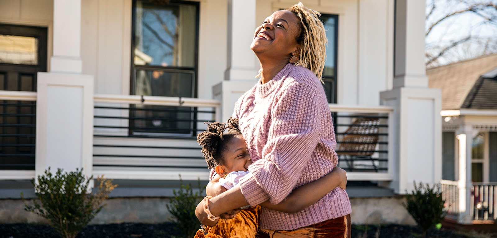 Woman smiling and laughing hugging a young girl