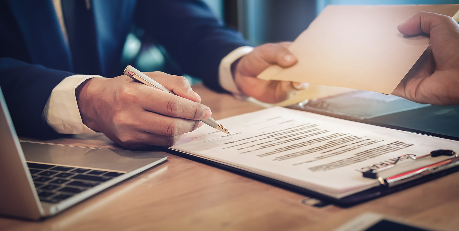 man holding a pen signing documents