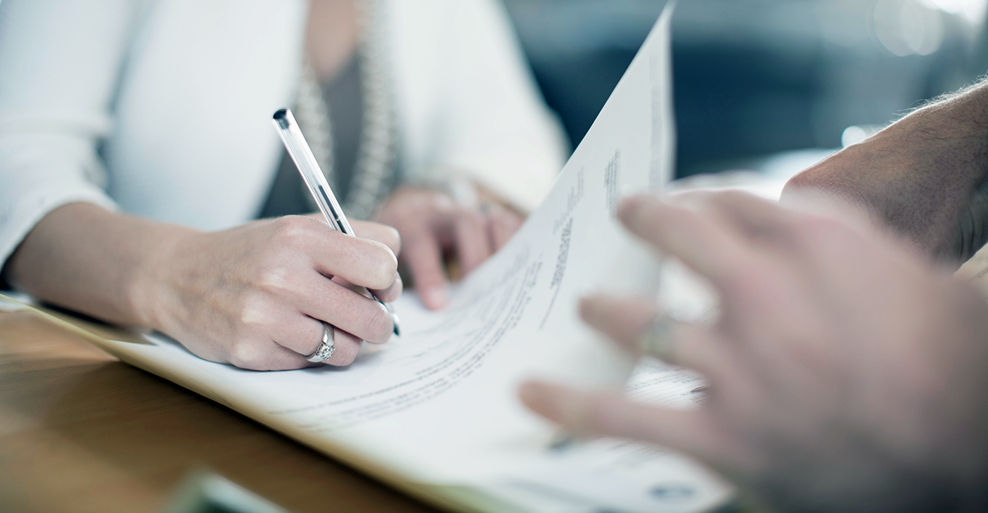 close up of a hand signing documents