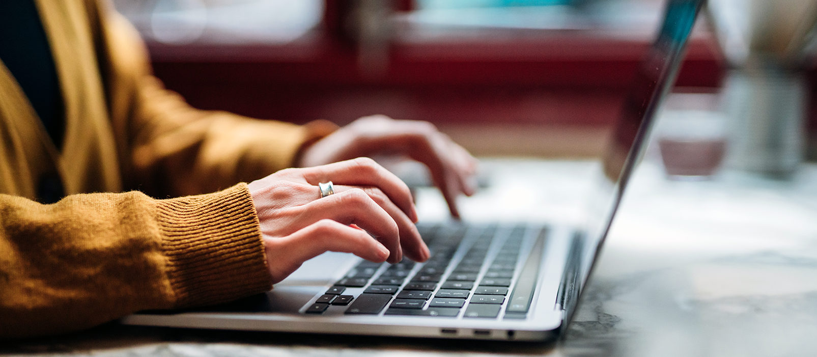 close up of woman's hand typing on a laptop