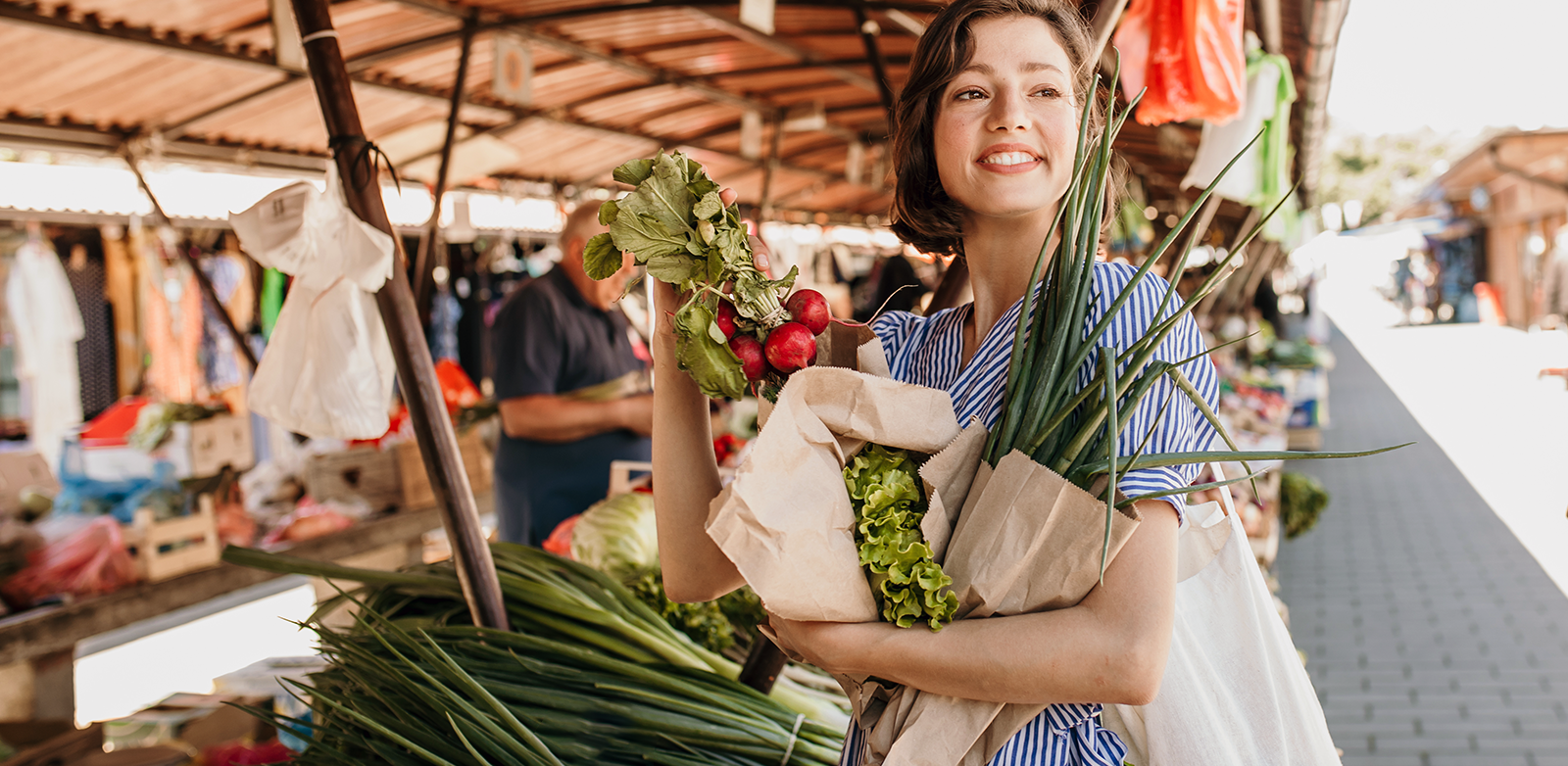 Woman buying flowers and produce at a farmer's market