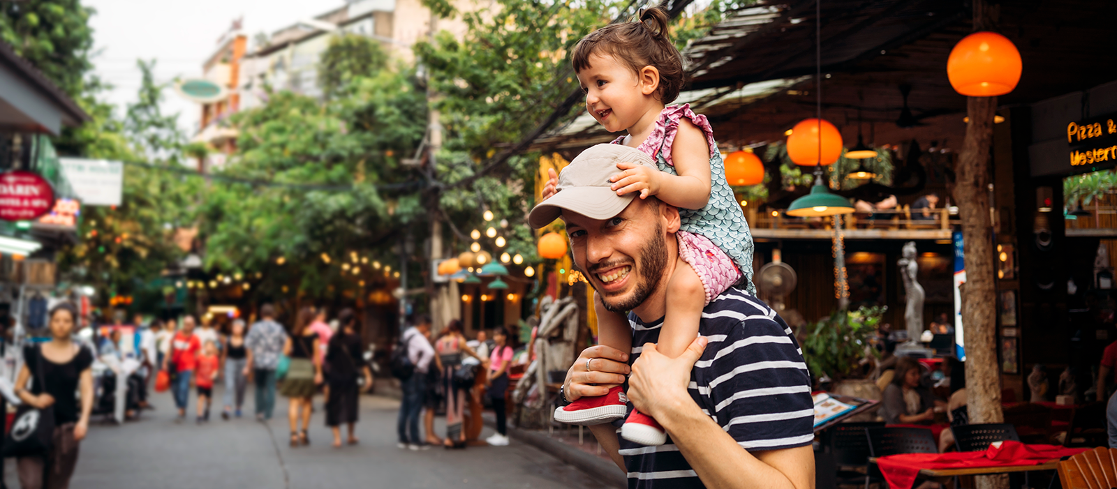 Man in Thailand with young girl sitting on his shoulders