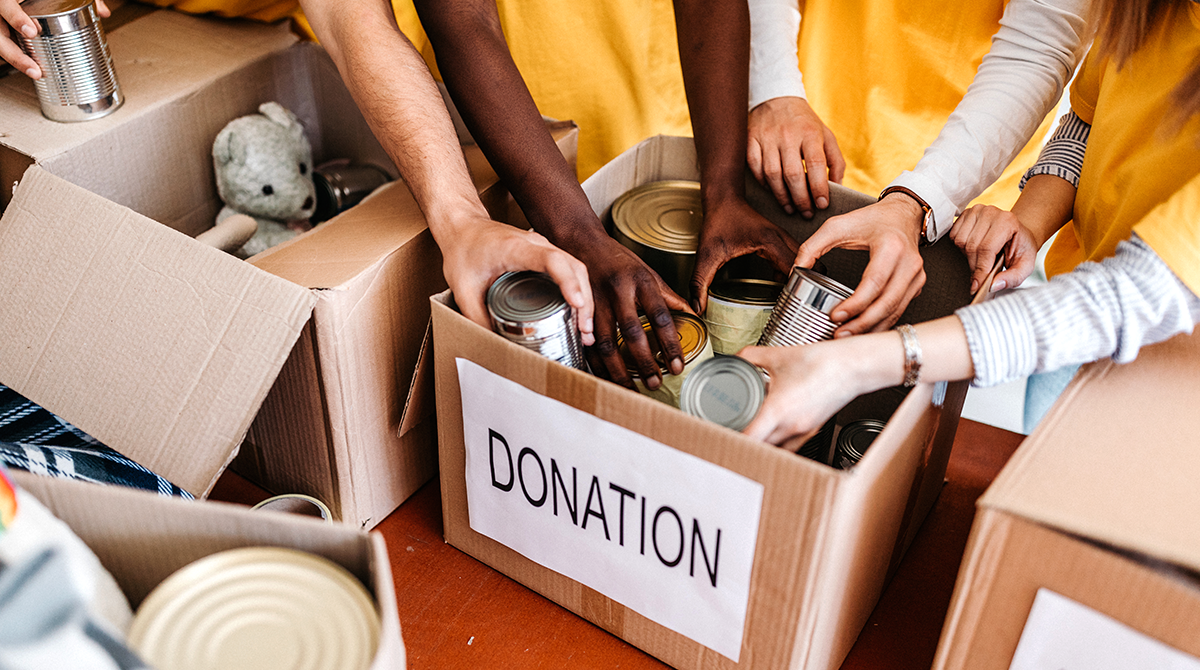 people reaching into a box of donations