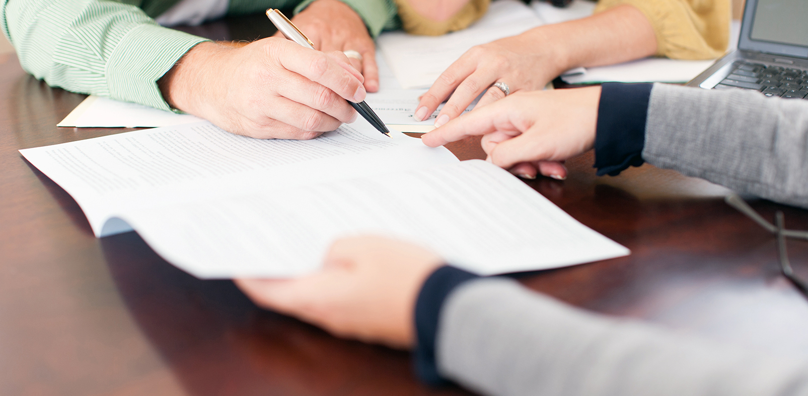 close up of person's hand signing a contract