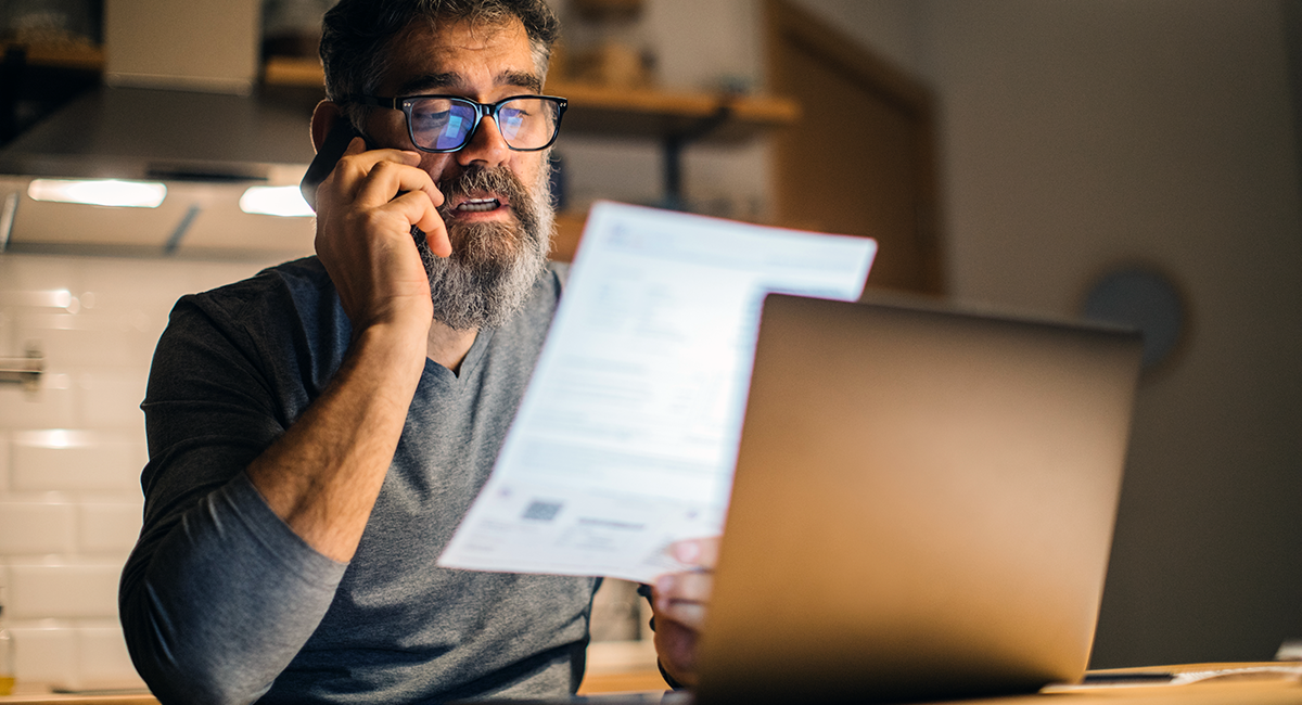Man on the phone while looking at a document