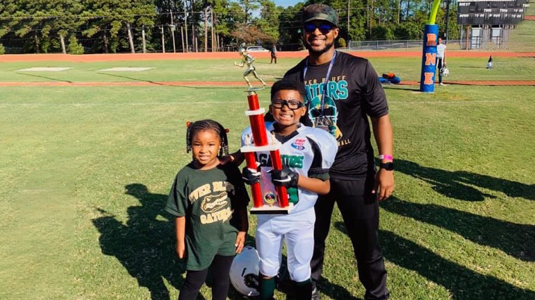 Quinton with his family (his son holding a football trophy)