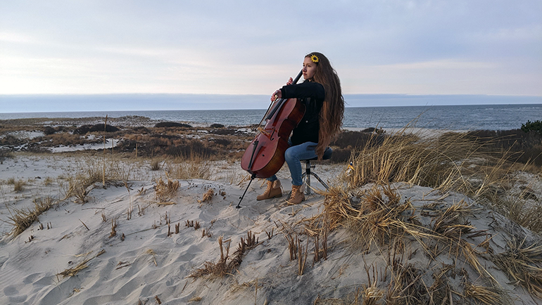 Kealia Grace Smith playing cello on the beach
