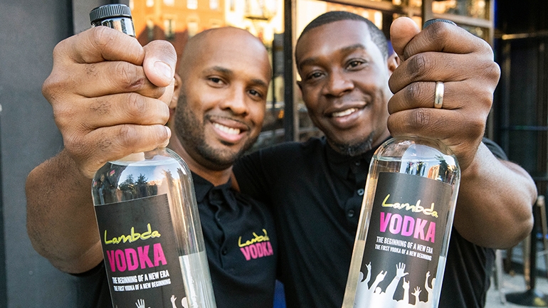 Charles Hughes and Richard Solomon holding Lambda Vodka vodka bottles