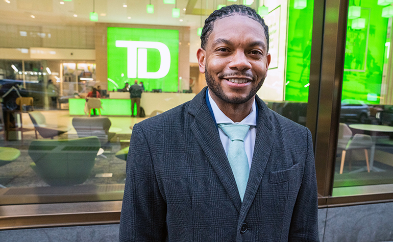 Marcus smiling in front of a TD Bank store