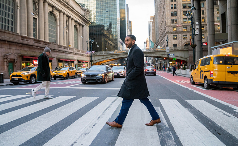 Marcus walking across a cross walk in NYC