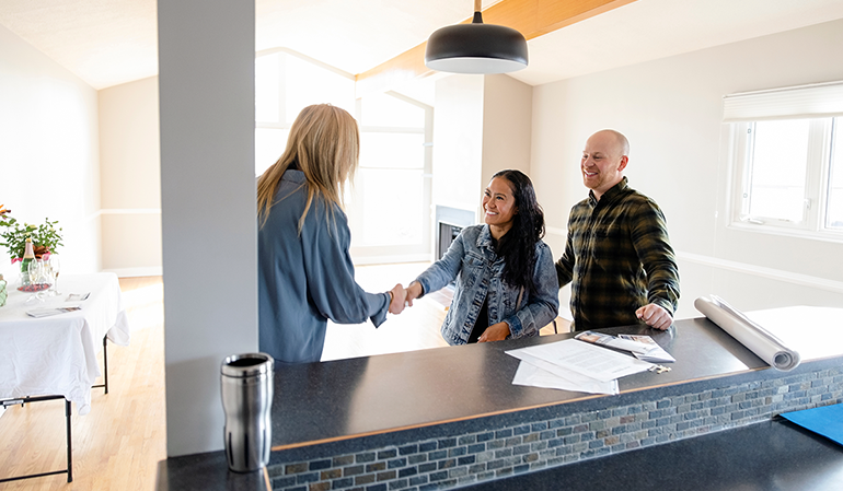 Couple shaking hands with a realtor