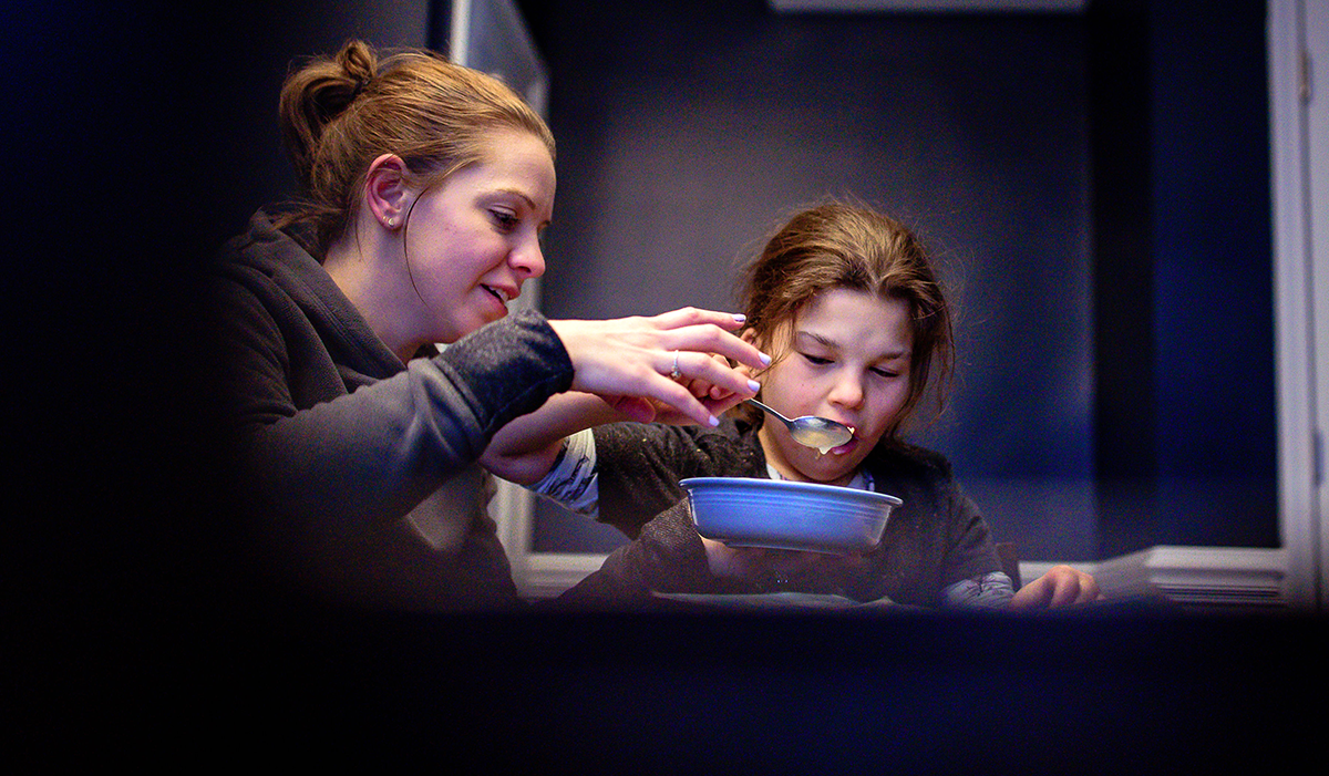 Woman feeding a young girl