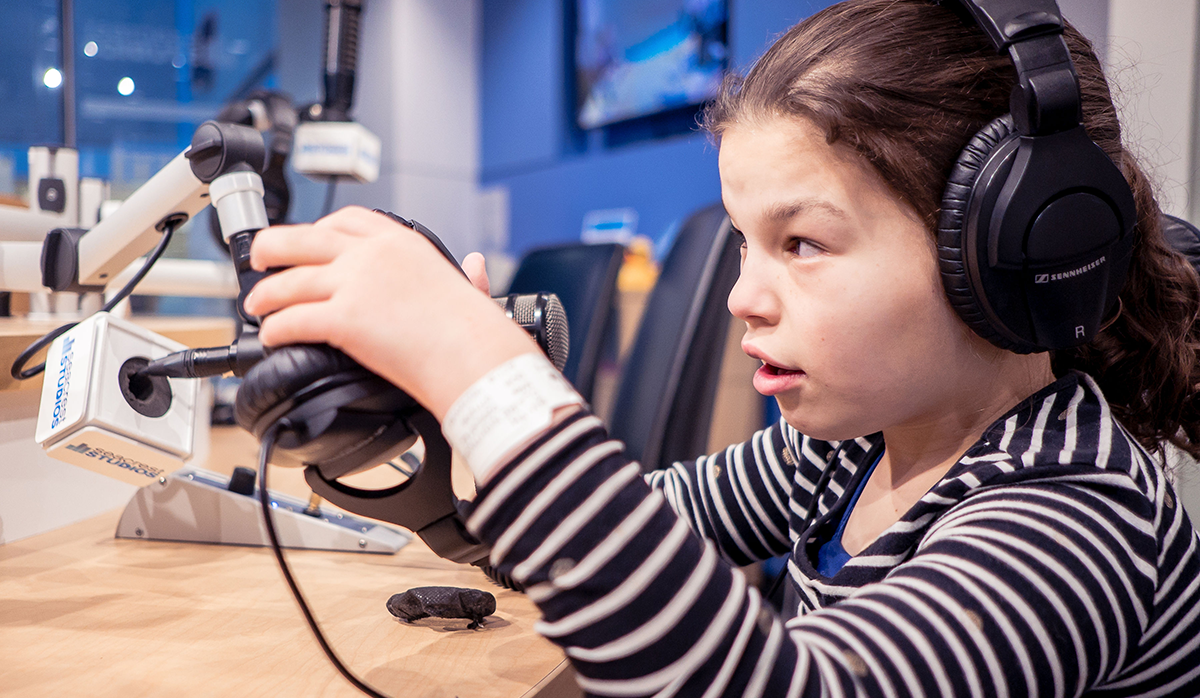 Young girl in headphones playing with a microphone