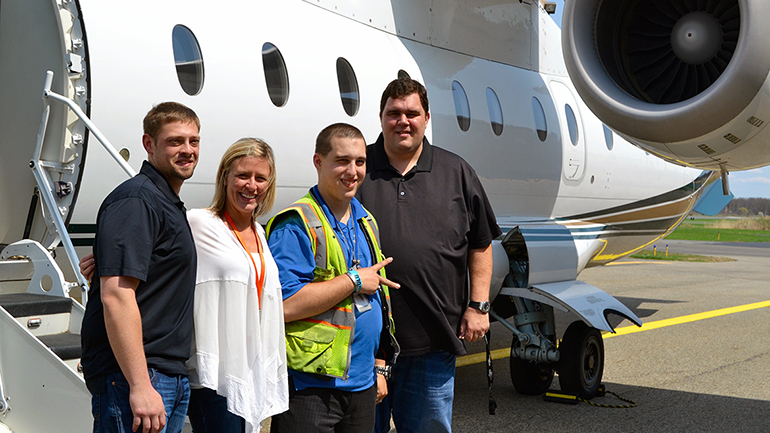 Nick in front of an airplane with his family