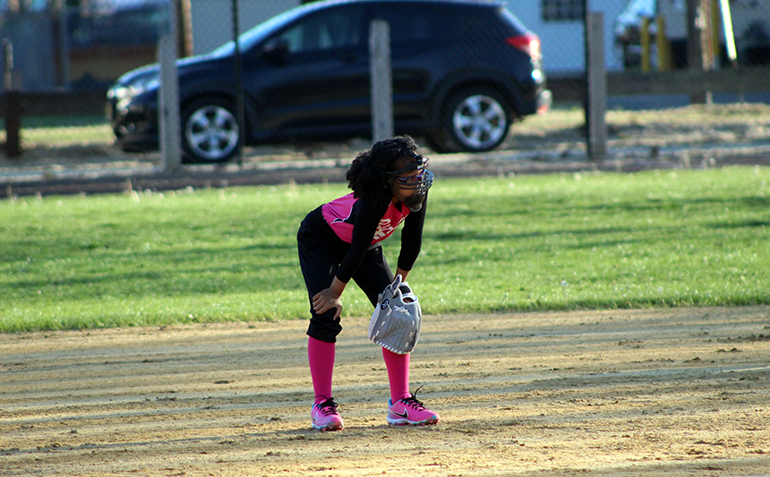 Young girl with a pink uniform playing softball